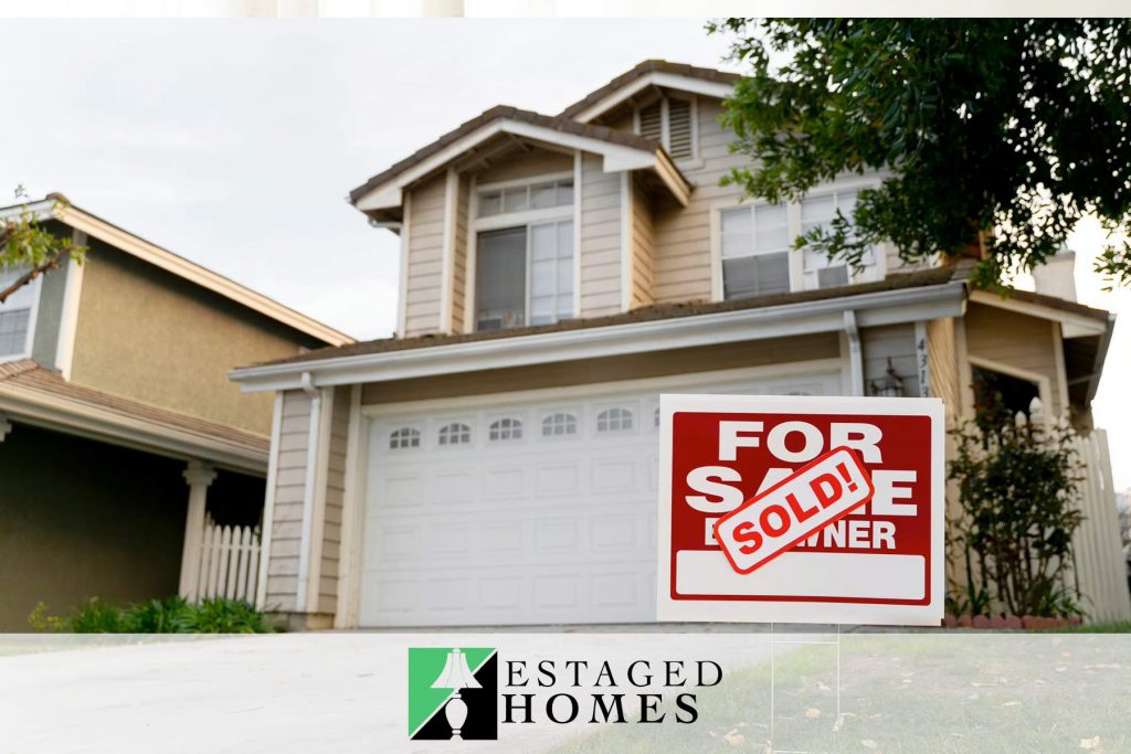 View of a real estate listing with a for sale and sold sign in the front yard