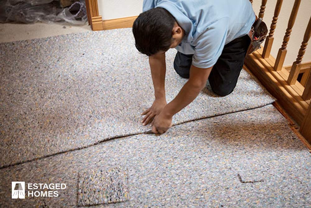 View of a contractor installing the padding to lay the carpeting on